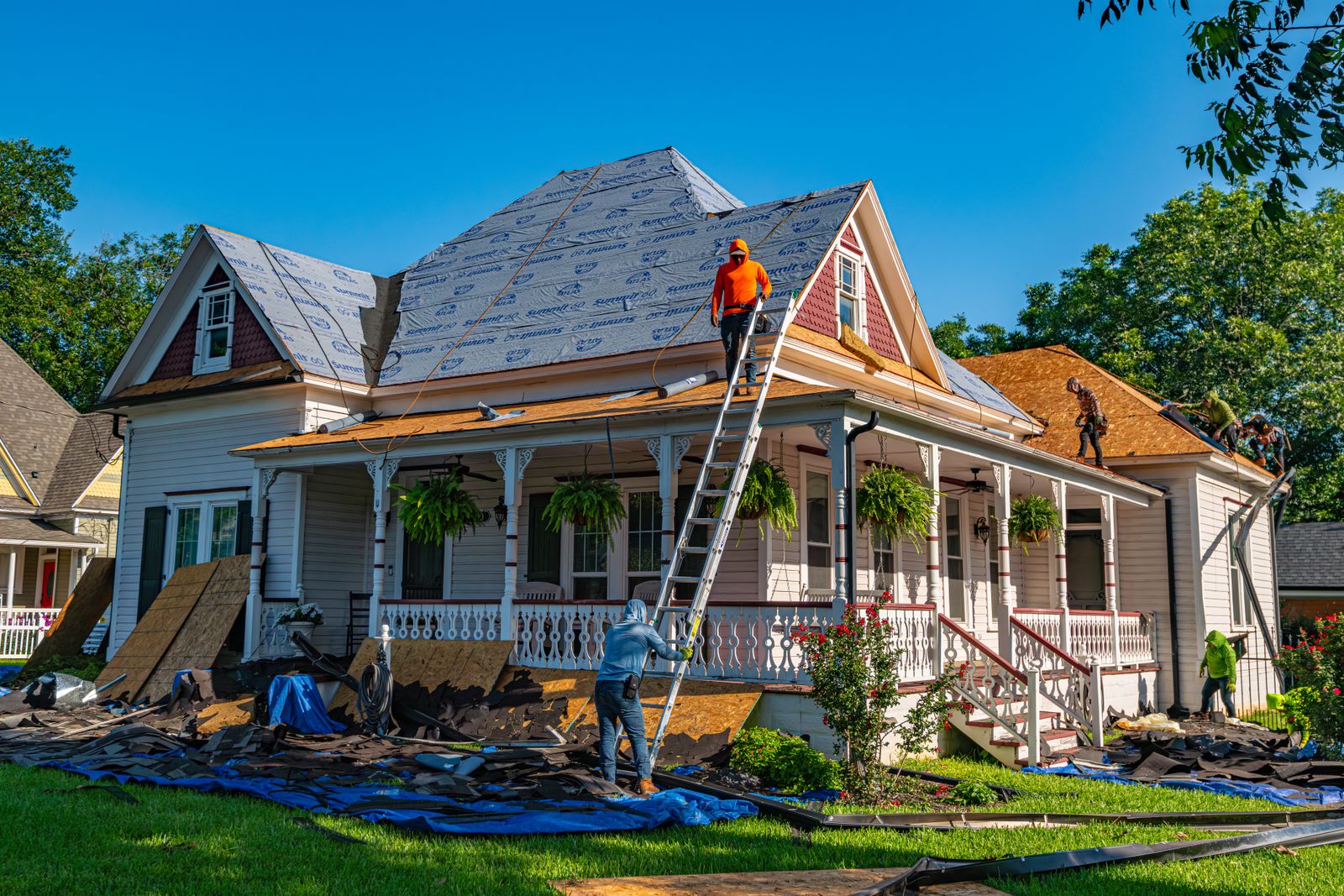 Roofers replacing shingles on a residential roof, tools and materials visible during an active roof repair job in Southwestern Ontario