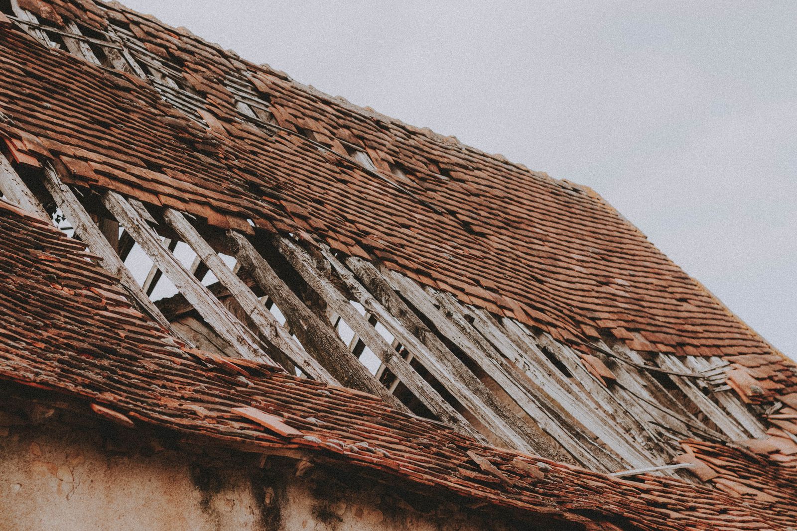 Close-up of a residential roof with missing and damaged shingles exposing the wood decking underneath, the kind of storm damage that sends Southwestern Ontario homeowners searching for a roofer